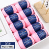 A box of ten skeins of pink Merino wool yarn for knitting sweaters, scarves, and hats.