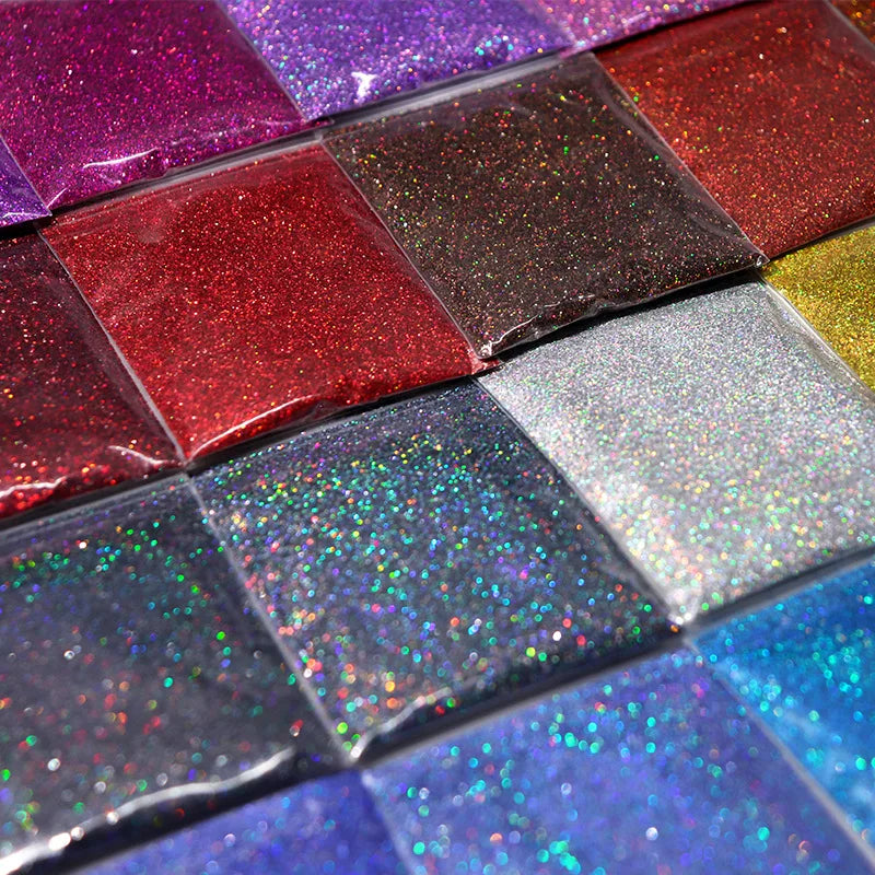 A palette of holographic fine glitter powder in various vibrant colors arranged in a grid.
