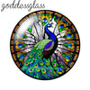 A round glass cabochon featuring a vibrant blue peacock with iridescent green and gold feathers.