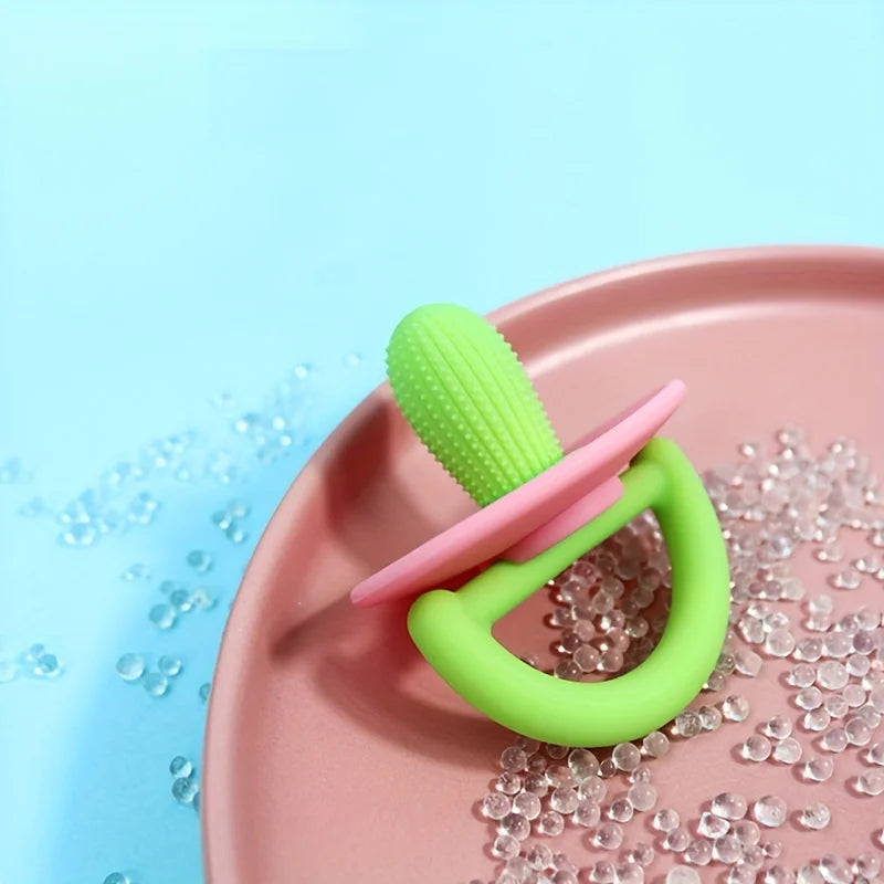 A silicone teething ring and pacifier tool in lime green and pink resting on a pink plate with clear beads.