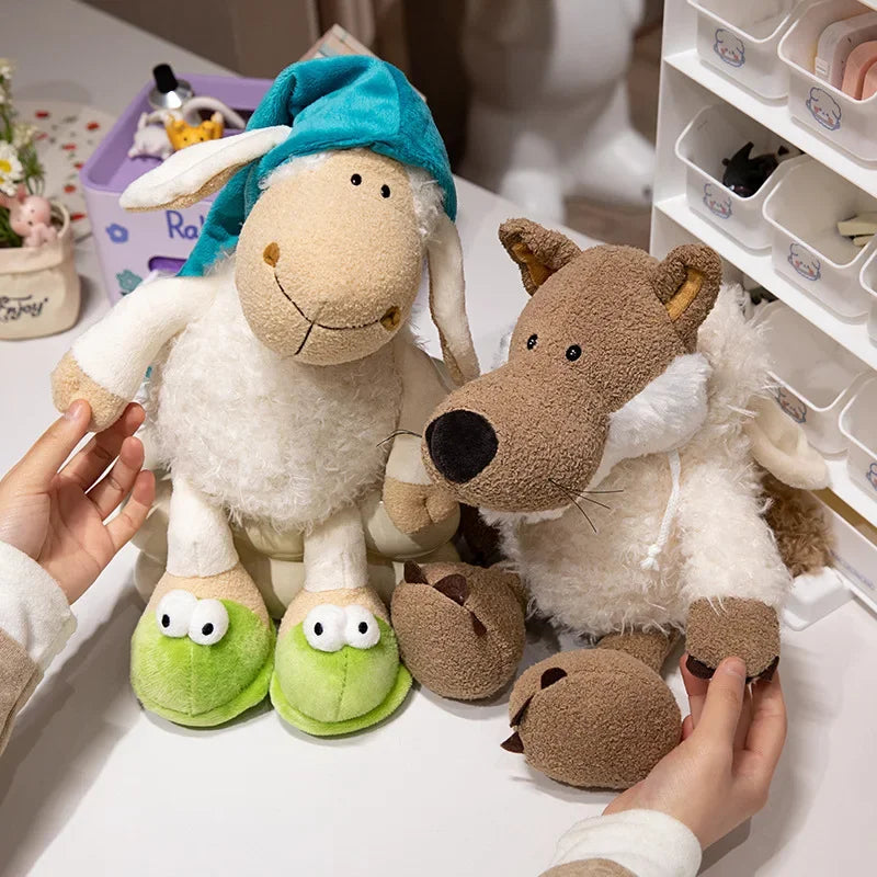 A person is holding a soft, white sheep plush toy with blue fabric ears and green feet next to a brown wolf plush toy.