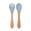 Une paire d'ustensiles à manger en silicone bleu clair, avec fourchette et cuillère, et manches en bois.