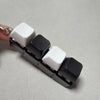 A fidget keychain featuring four clicky acrylic key buttons in white and black.