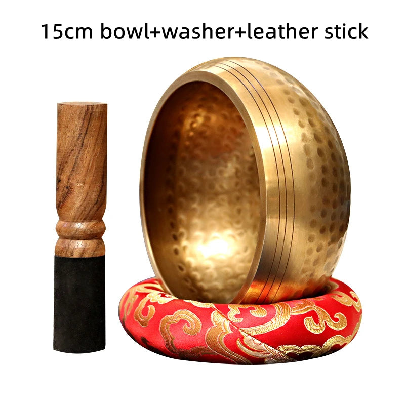 A brass singing bowl with a leather stick and a red patterned coaster is shown.
