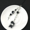 Anime-inspired keychain featuring a black silhouette charm and pearl beads on a black cord
