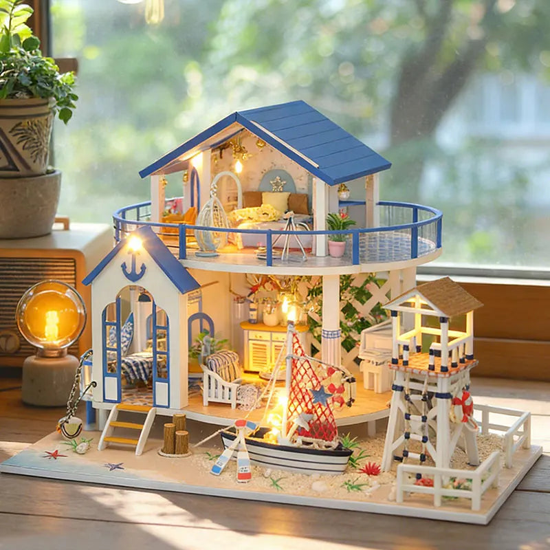 A detailed miniature dollhouse kit of a seaside beach house with blue accents and LED lights on a wooden base.