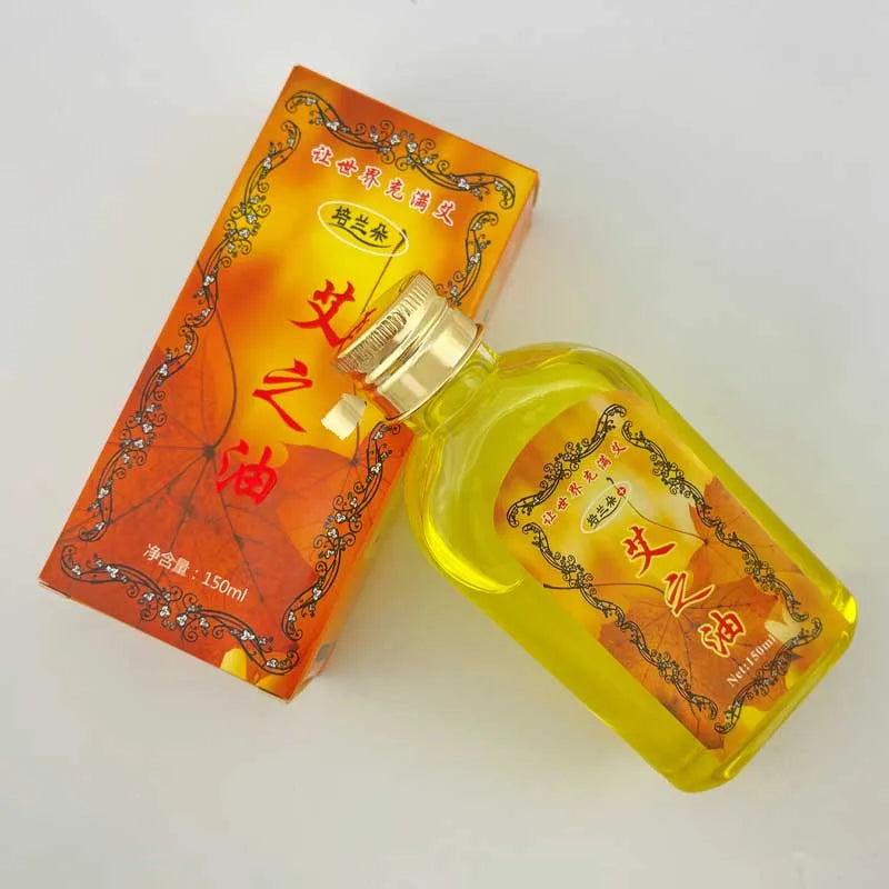 A glass bottle of Moxibustion Body Massage Oil with an orange label and a cardboard box.
