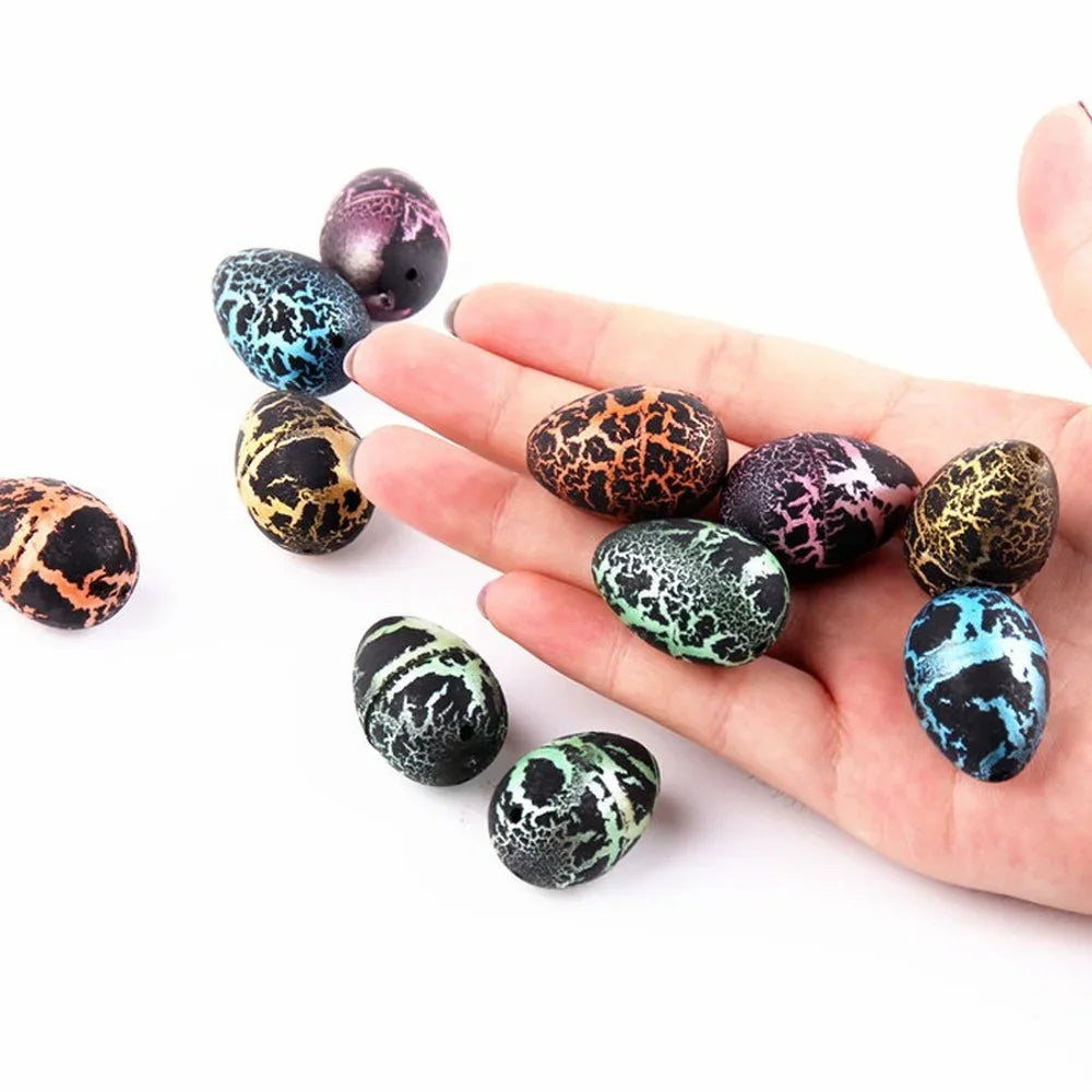 A hand holds several colorful, speckled dinosaur eggs of various sizes.