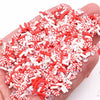 A pile of red and white striped polymer clay slices for DIY crafts held in a hand.