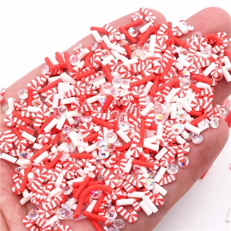A pile of red and white striped polymer clay slices for DIY crafts held in a hand.