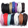 A collection of round braided leather cords in various colors including black, gold, blue, purple, white, and brown.