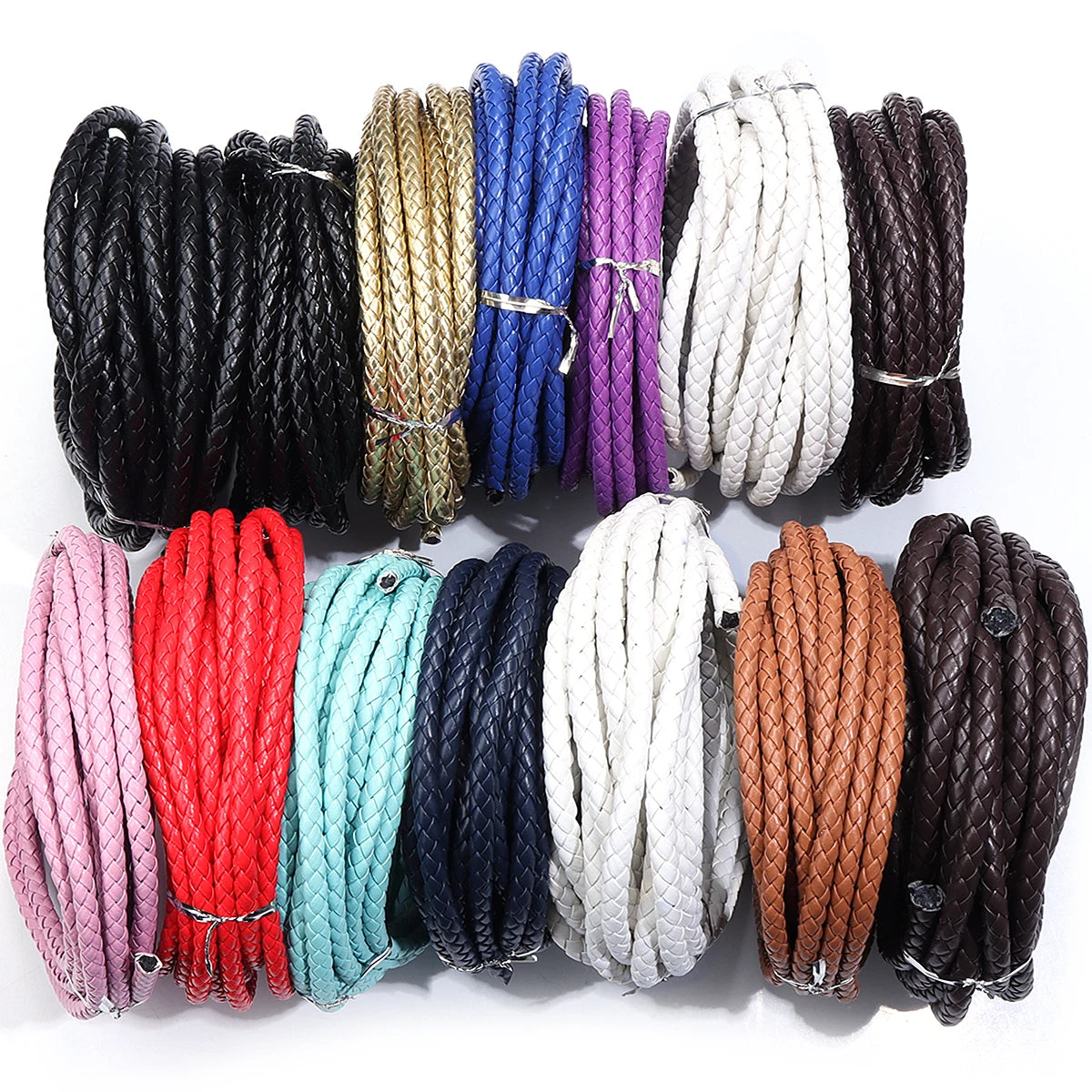 A collection of round braided leather cords in various colors including black, gold, blue, purple, white, and brown.