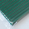 A close-up view of a sheet of dark green polymer clay, rolled and sealed in clear plastic packaging.