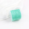 A roll of 0.8mm cotton nylon macrame cord in mint green is shown against a white background.