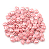 A pile of pink heart-shaped acrylic beads for jewelry making