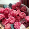 A collection of realistic pink and red rose silicone molds used for candle, soap, and crafting.