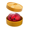 A set containing a yellow plastic lid and a red glitter dumpling squishy toy.