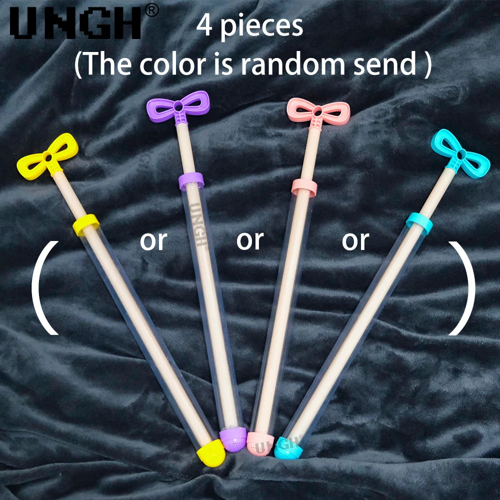 Four assorted colored pull-out water guns displayed on a dark fabric background.