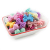 A collection of colorful silicone bow tie beads in various shades of pink, purple, blue, and yellow are displayed in a white 
