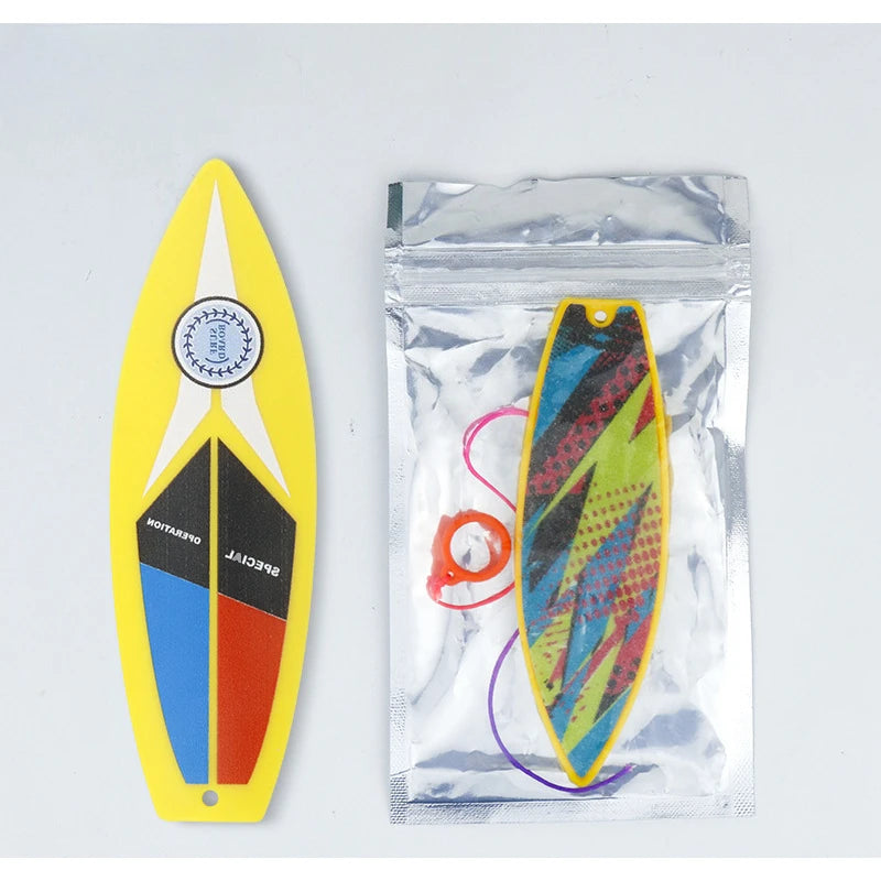 A yellow finger skateboard is shown next to a clear plastic pouch containing an orange and green finger skateboard.
