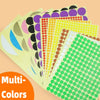 A stack of round self-adhesive dot labels in various colors and sizes, including yellow, pink, black, orange, and green.