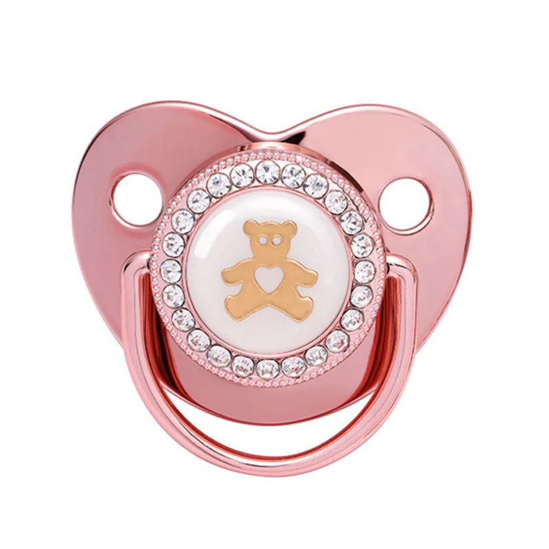 A rose gold crystal bling pacifier with a bear charm for newborns.