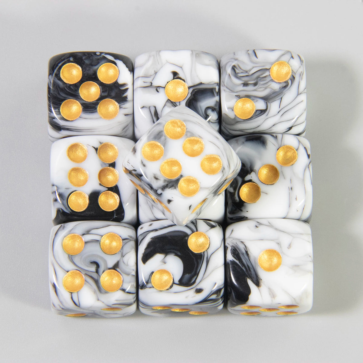 A set of ten 16mm acrylic dice featuring black and white marbled patterns with gold dots.