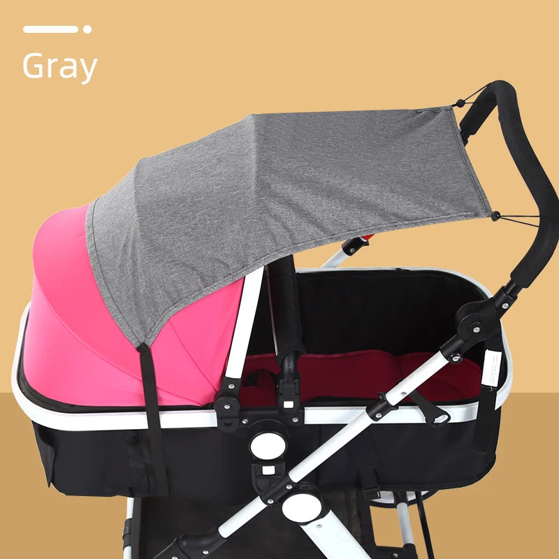 Gray sun shade canopy attached to a black baby stroller.