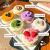 A display of various colorful and decorated soufflé toys including chocolate bear, tarot, blueberry, matcha, and strawberry f