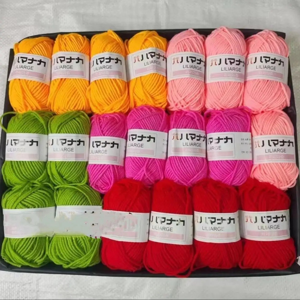 A pack of 20 skeins of various colored yarn in pink, orange, and green for knitting and crochet projects.