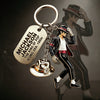 A metallic keychain featuring a figure of Michael Jackson in a dance pose.