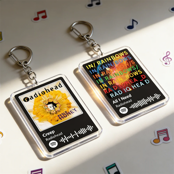 Two clear acrylic keychains featuring the radiohead logo and text like In/Rainbows and Rad IQ Head