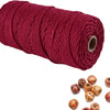 A spool of deep red natural cotton macrame rope used for crafts and decor.