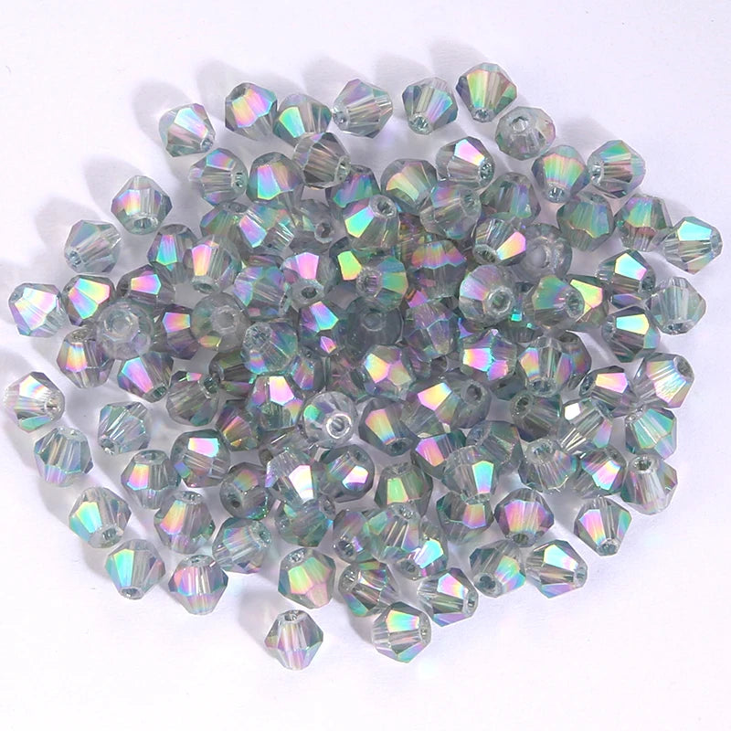 A pile of small, faceted, iridescent glass beads in various shades of green and purple.