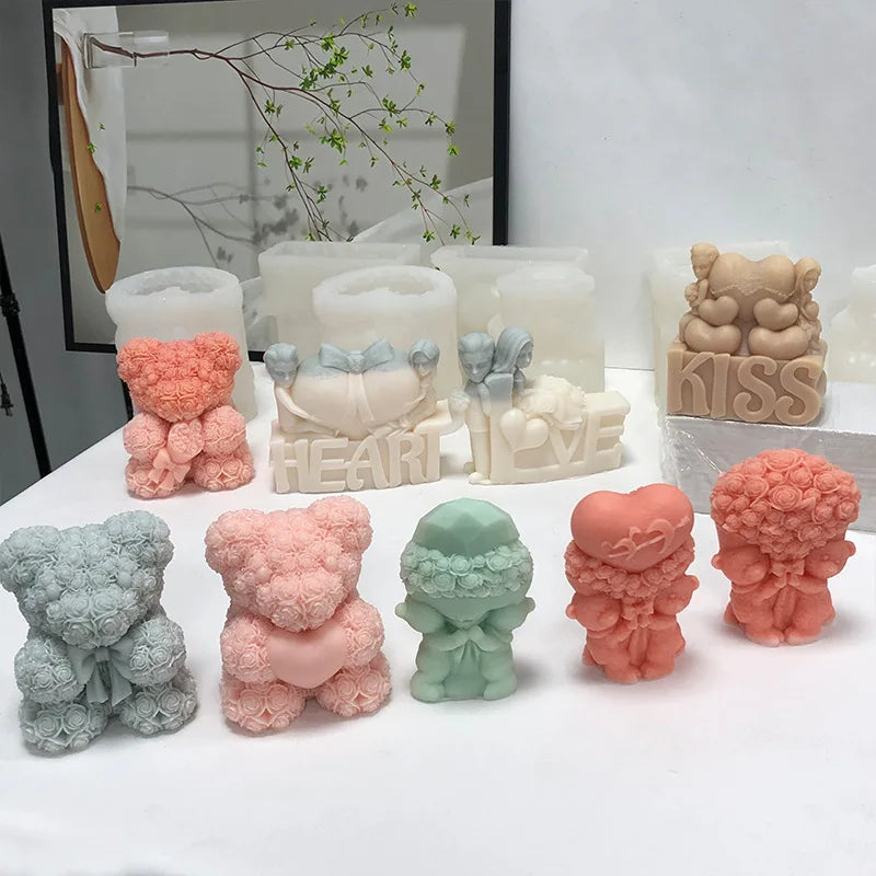 A collection of pink, peach, and mint green silicone candle molds shaped like bear hugs and hearts for DIY crafts.