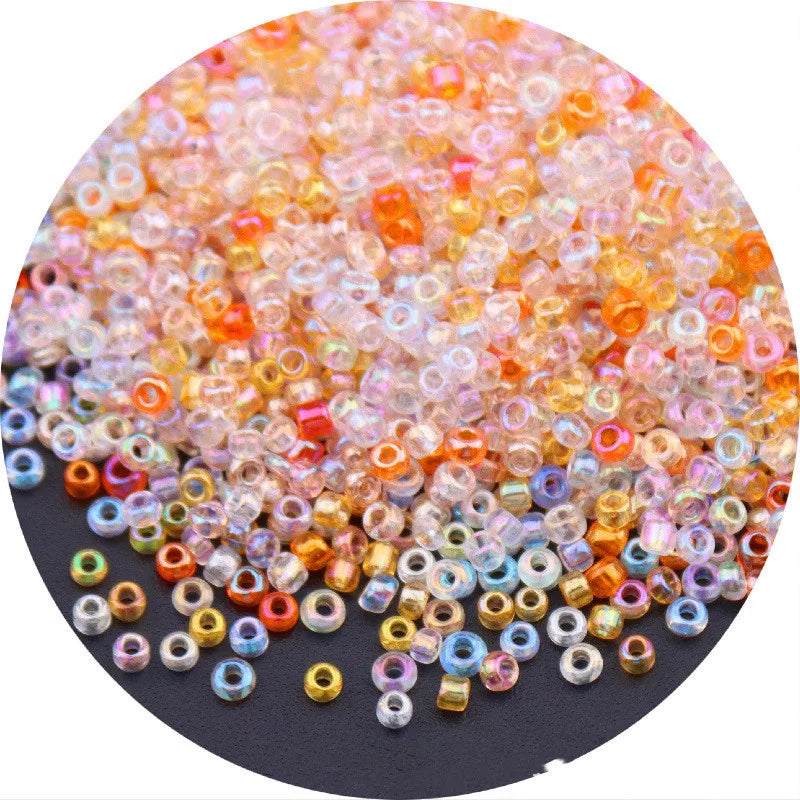 A close-up view of various colored glass rice beads in a pile, including pink, orange, yellow, and blue shades.