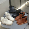 A collection of black and tan faux leather winter boots for kids, including ankle boots and lace-up styles.