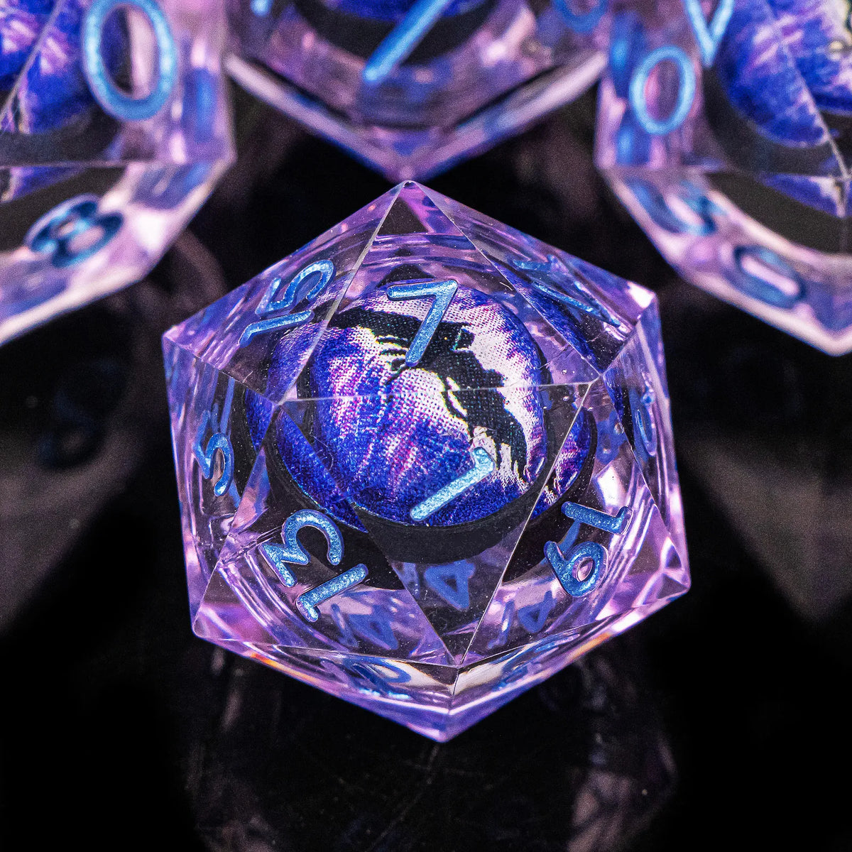 A close-up of a set of seven purple and blue polyhedral resin dice for tabletop role-playing games.