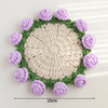 Hand-crocheted lily of the valley coasters featuring purple and green yarn in a circular pattern