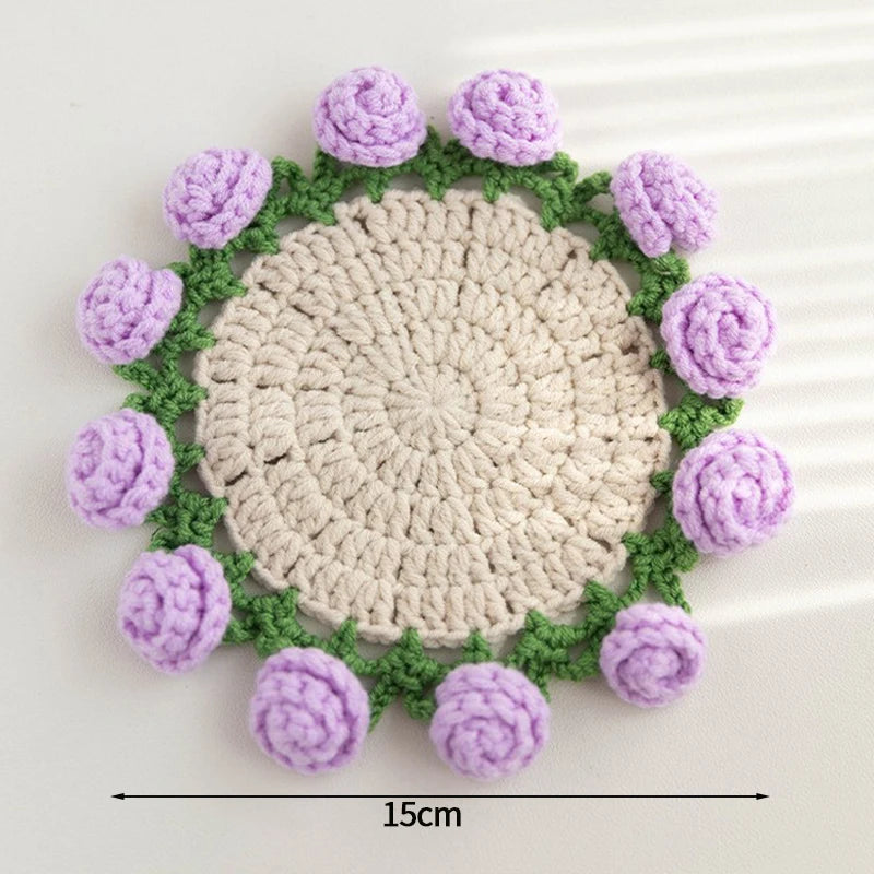 Hand-crocheted lily of the valley coasters featuring purple and green yarn in a circular pattern