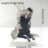 A black and white anime figure of a character in a dynamic pose is displayed on a clear acrylic stand.