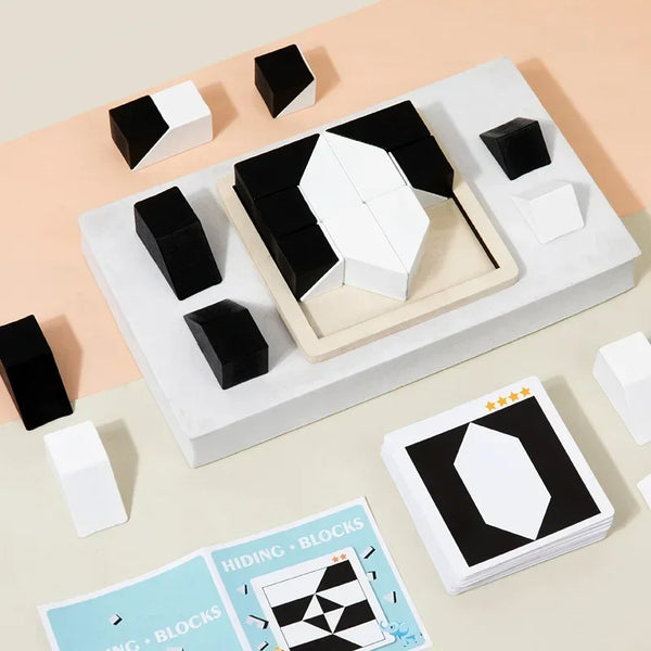 A collection of black and white geometric wooden building blocks arranged on a white surface.
