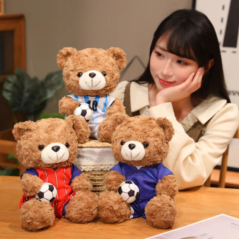 A woman is posing with several cute football bear plush toys on a wooden surface.