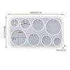 A white silicone mold set with multiple circular cavities for making epoxy resin earrings and pendants.