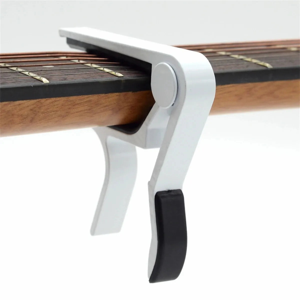 A silver aluminum alloy quick-change guitar capo clamped onto a wooden fretboard.
