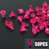A pile of bright pink faceted gems and crystals, including various shapes, is displayed on a dark surface.