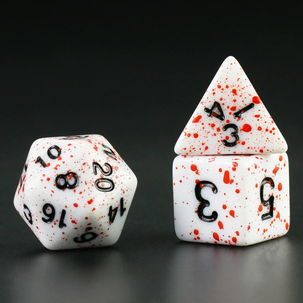 A set of acrylic dice, including a tetrahedral die and a cube, with red blood effect markings on a dark background.