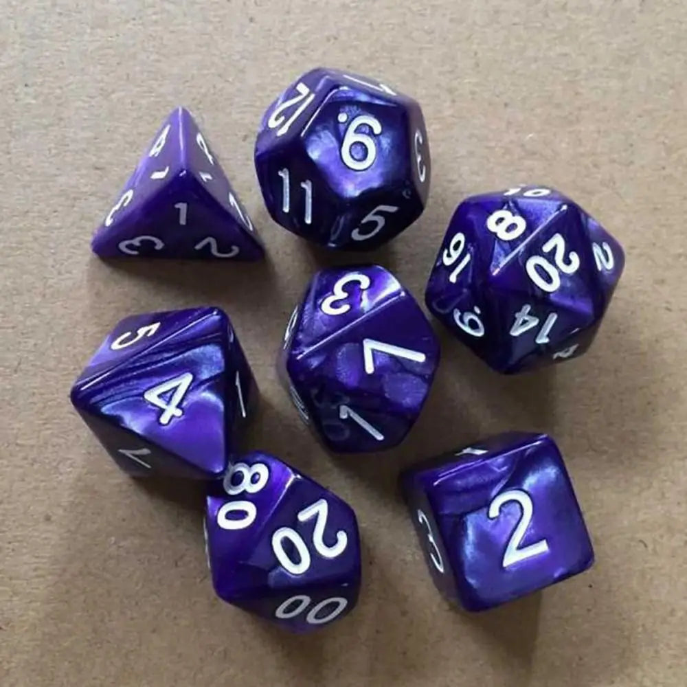 A collection of ten purple acrylic polyhedral dice scattered on a brown surface.