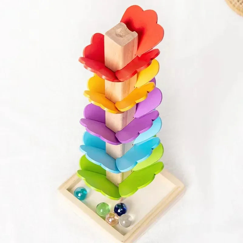 A wooden rainbow ball track toy featuring colorful blocks stacked vertically.
