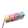 A clear plastic case holding five pastel colored keyboard fidget toys or clickers.